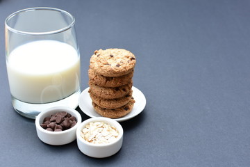 Oatmeal cookies and chocolate chips on black background