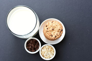 Oatmeal cookies and chocolate chips on black background