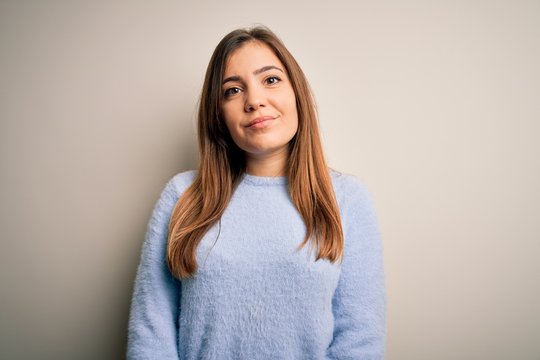 Beautiful young woman wearing casual winter sweater standing over isolated background Relaxed with serious expression on face. Simple and natural looking at the camera.