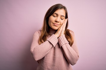 Beautiful young woman wearing turtleneck sweater over pink isolated background sleeping tired dreaming and posing with hands together while smiling with closed eyes.