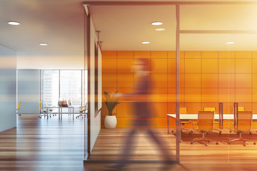 Man passing by yellow meeting room