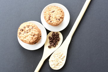 Oatmeal cookies and chocolate chips on black background