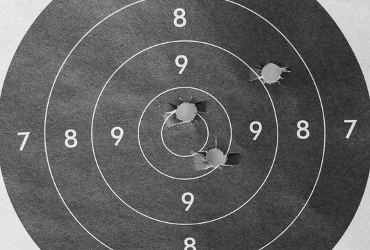 Close up of a shooting target and bullseye with bullet holes