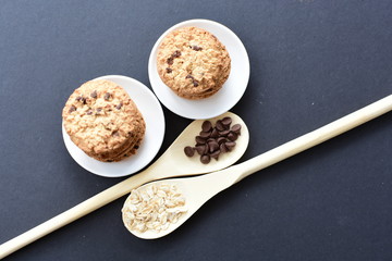 Oatmeal cookies and chocolate chips on black background