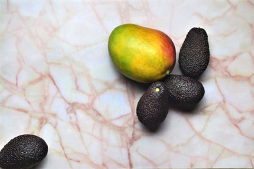 Frutas tropicales, mango y aguacate sobre marmol