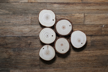 plano cenital con seis medallones de madera clara formando un triángulo sobre mesa de madera oscura