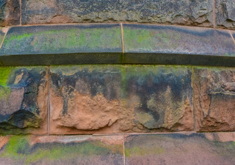 Elemental architectural design of the masonry, on which unicellular green algae grow on the walls...