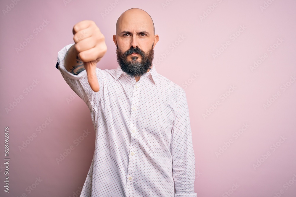 Poster handsome bald man with beard wearing elegant shirt over isolated pink background looking unhappy and