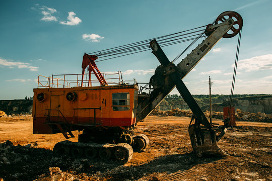 Excavator machine works in limestone pit quarry