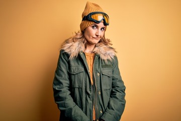 Middle age beautiful blonde skier woman wearing snow sportwear and ski goggles looking sleepy and tired, exhausted for fatigue and hangover, lazy eyes in the morning.