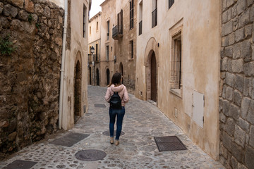 Fototapeta na wymiar street, architecture, old, building, city, spain, town, europe, ancient, woman, stone, historic, tourism, travel, church, tourist, medieval, arch, walking, house, alley, ibiza, road, people