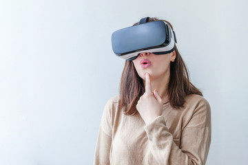 Smile young woman wearing using virtual reality VR glasses helmet headset on white background. Smartphone using with virtual reality goggles. Technology, simulation, hi-tech, videogame concept