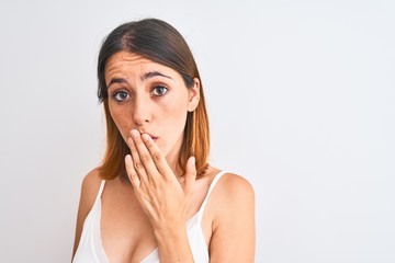 Beautiful redhead woman wearing casual white t-shirt over isolated background cover mouth with hand...