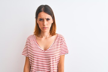 Fototapeta premium Beautiful redhead woman wearing casual striped red t-shirt over isolated background skeptic and nervous, frowning upset because of problem. Negative person.