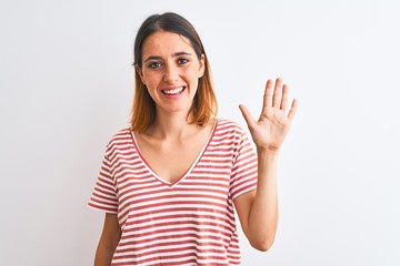 Beautiful redhead woman wearing casual striped red t-shirt over isolated background showing and pointing up with fingers number five while smiling confident and happy.