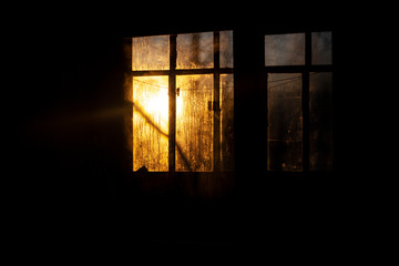 Sunrise outside the window. Misted glass against the backdrop of the rising sun. Winter morning. . Simple background. The ratio of cold and warm colors. Texture of water condensate on glass.