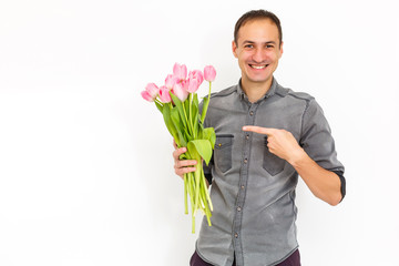 Man with flowers. Romantic Man with bouquet of tulips for birthday. Happy woman's day. Giving bouquet of flowers. Handsome man giving flowers. White background. Horizontal photo.s