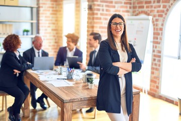 Group of business workers smiling happy and confident working together in a meeting. One of them,...