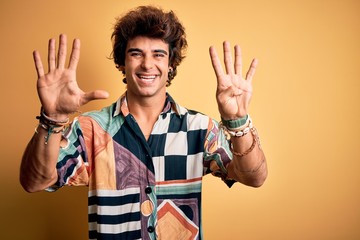 Young handsome man on vacation wearing summer shirt over isolated yellow background showing and...