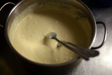 The dough is prepared for pancakes. Liquid in the pan. Cooking products from flour and eggs. Cookware for cooking. A recipe from my grandmother's past. Baking liquid.