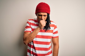 Young handsome african american man with dreadlocks wearing striped t-shirt and wool hat feeling unwell and coughing as symptom for cold or bronchitis. Health care concept.
