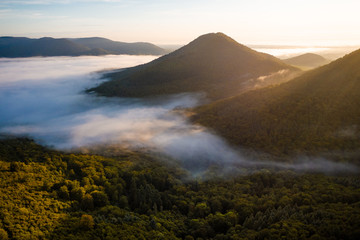 Sonnenaufgang in einer bergigen Landschaft im Wald