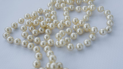 Beautiful pearls on white background. Feminine necklace jewelry. Fashionable background
