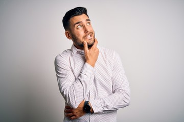 Young handsome man wearing elegant shirt standing over isolated white background Thinking worried about a question, concerned and nervous with hand on chin