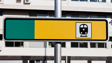 Blank yellow and green reflective road train station sign on the street