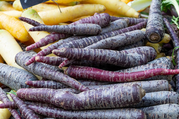 Pile of purple carrots, Daucus carota, on a market stall. Background image