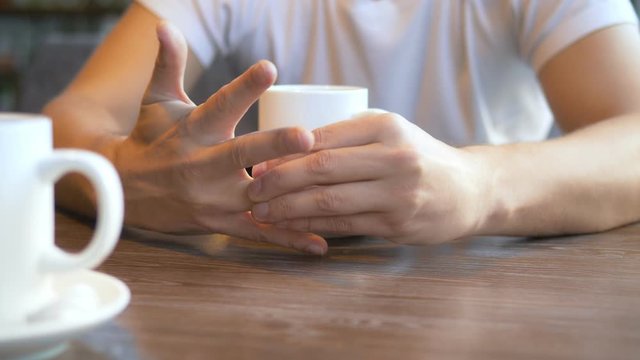 closeup. man takes off a wedding ring while sitting in a cafe.