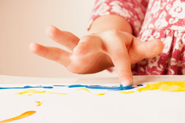 Close up child girl painting with colorful finger. Happy childhood, art, education concept.