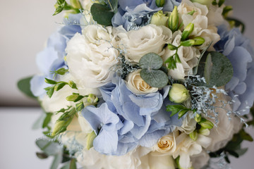Top view on beautiful and stylish wedding bouquet of white roses and eucalyptus greenery. Summer floral composition.