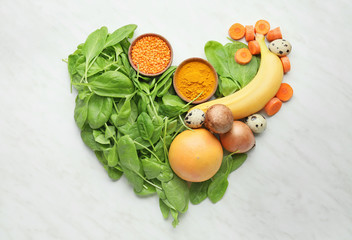 Healthy products in shape of heart on white background