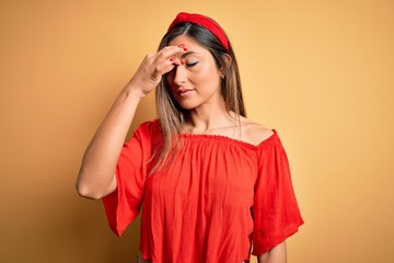 Young beautiful woman colorful summer style over yellow isolated background tired rubbing nose and eyes feeling fatigue and headache. Stress and frustration concept.