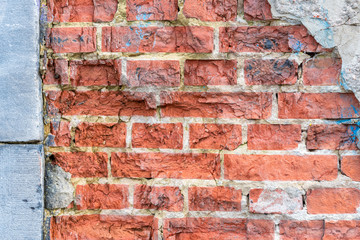 old brick wall with rough structure and natural stone edge
