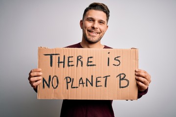 Young activist man holding protest banner for climate change and environment change with a happy face standing and smiling with a confident smile showing teeth