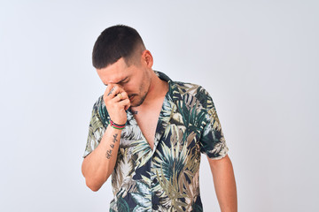 Young handsome man wearing Hawaiian summer shirt over isolated background tired rubbing nose and eyes feeling fatigue and headache. Stress and frustration concept.