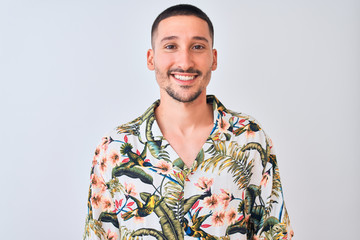 Young handsome man wearing Hawaiian summer shirt over isolated background with a happy and cool...
