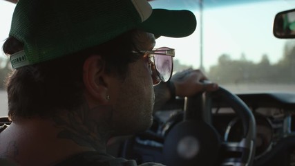 Handsome Young Man In Cap And Sunglasses Drives Car.