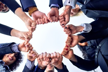 Group of business workers standing bumping fists at the office