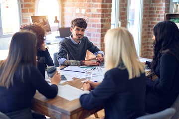 Group of business workers smiling happy and confident. Working together with smile on face  using laptop and speaking at the office