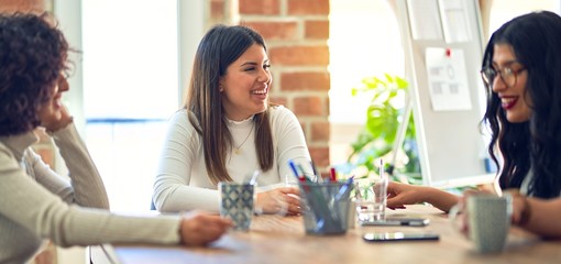 Group of businesswomen smiling happy and confident. Sitting relaxed with smile on face. Speaking taking rest at the office