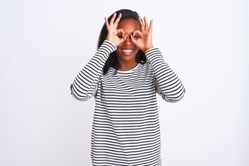 Beautiful young african american woman wearing winter sweater over isolated background doing ok gesture like binoculars sticking tongue out, eyes looking through fingers. Crazy expression.