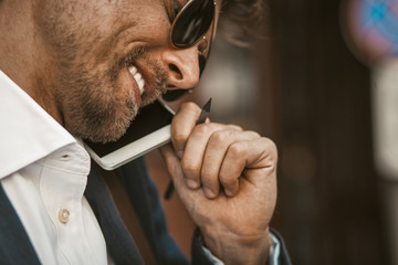 Portrait of a serious young white collar worker happy smiling while talking on the phone. Color...