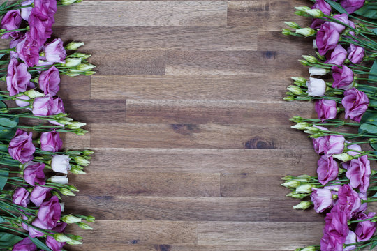 purple and white eustom roses on wooden background. Empty space for design.