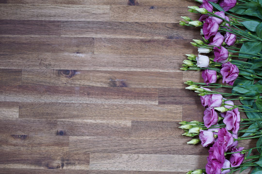 purple and white eustom roses on wooden background. Empty space for design.