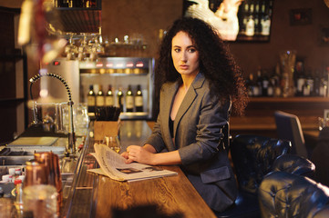Elegant lady in a business suit, in a restaurant at a bar counter alone