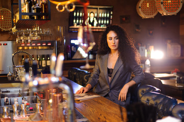Fototapeta na wymiar Elegant lady in a business suit, in a restaurant at a bar counter alone