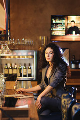 Elegant lady in a business suit, in a restaurant at a bar counter alone